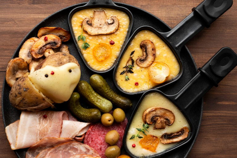 Service à raclette avec fromage fondu, pommes de terre charcuterie et cornichons